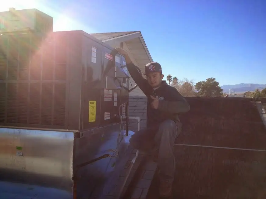 HVAC technician performing HVAC Inspection on a rooftop unit in Park City